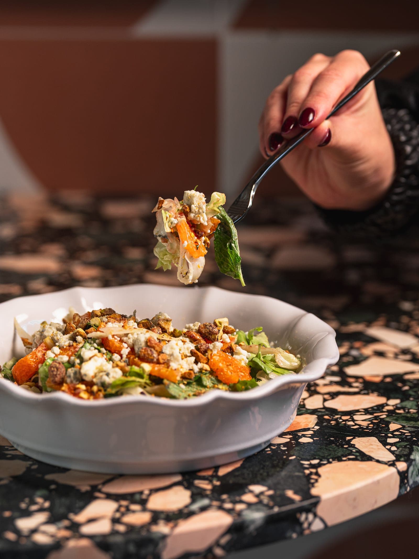 A forkful of the escarole and shaved fennel salad, with the arched wall behind